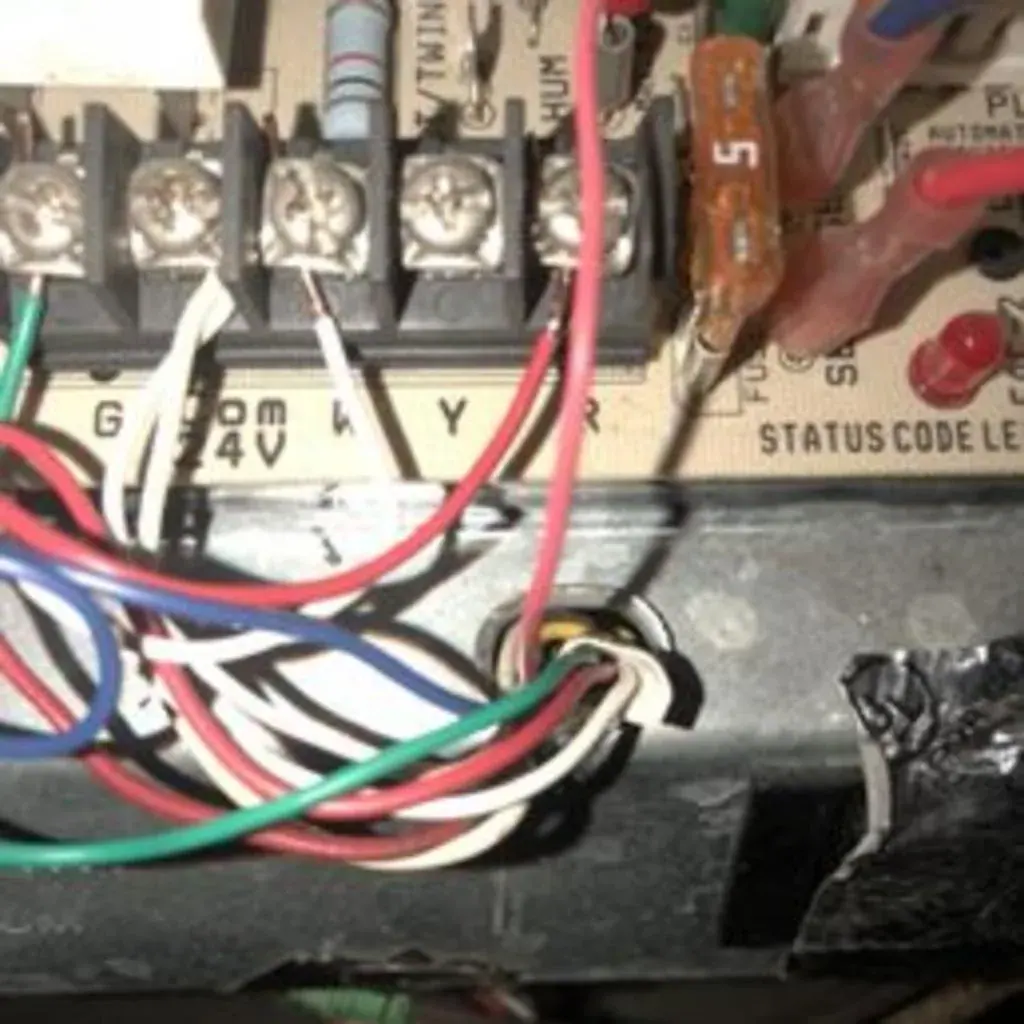 Furnace control board with thermostat wiring and status light during a heating repair in White Plains, NY