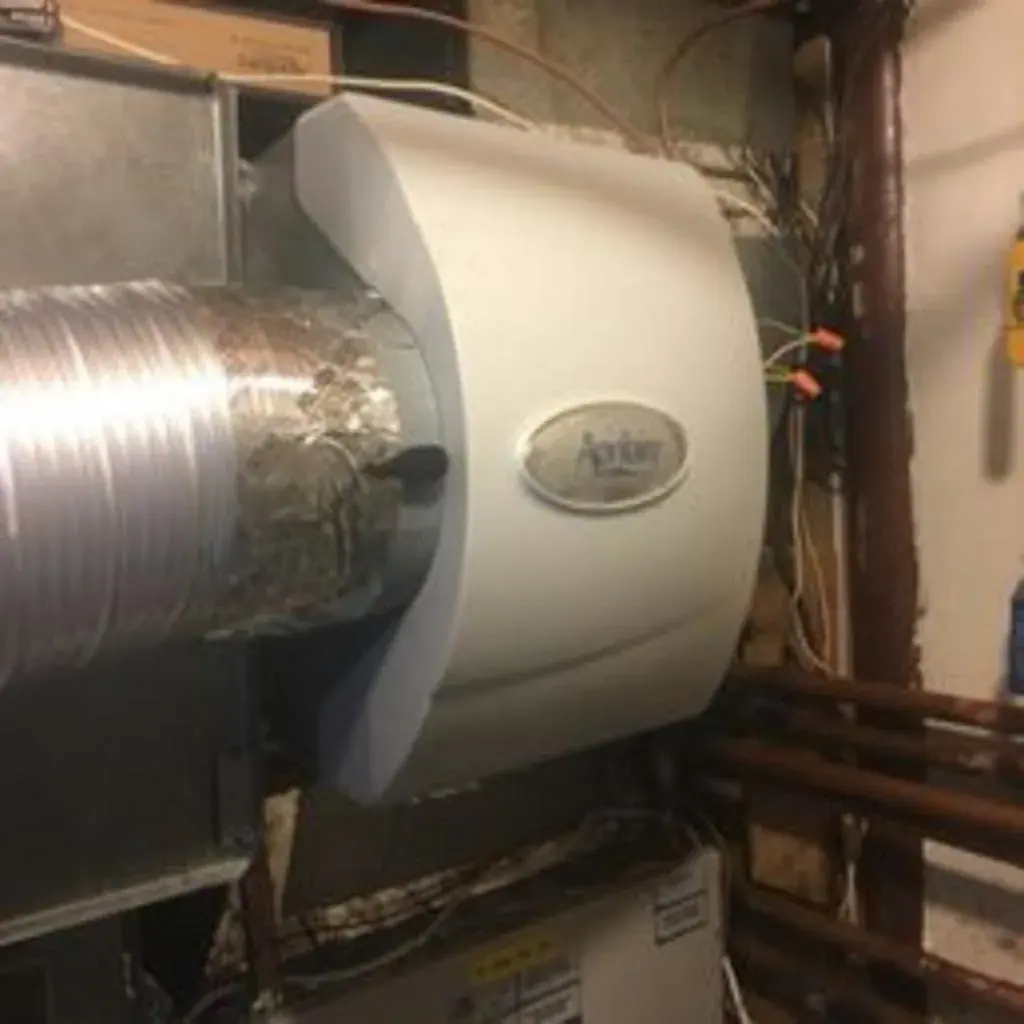 Aprilaire whole-house humidifier mounted on a furnace plenum in a White Plains, NY basement